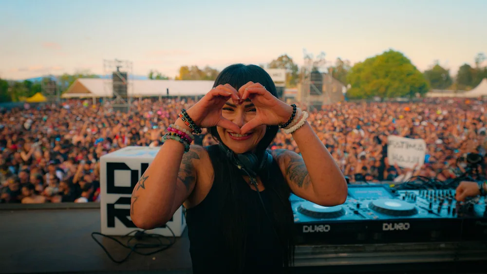 Fatima smiling and making a heart with her hands in front of the Duro crowd